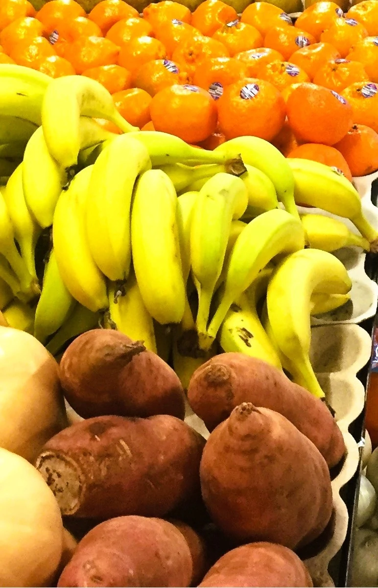 A cluster of ripe yellow bananas arranged together on a white background.
